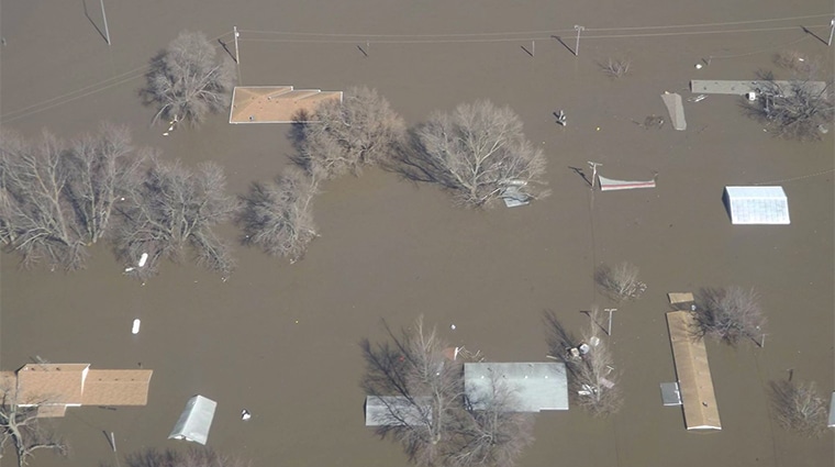 Overhead view of a flooded residential neighborhood with water levels up to roof lines.